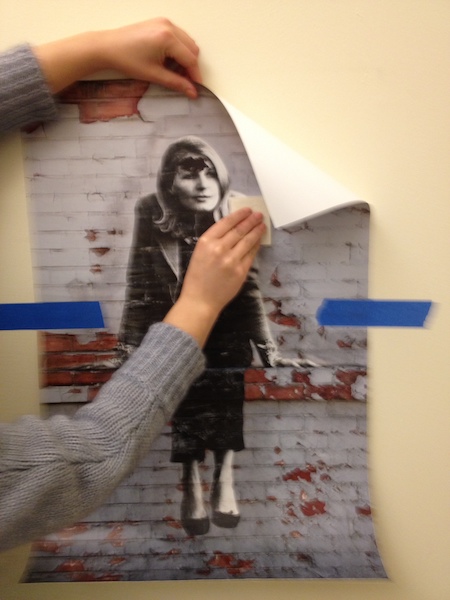 Photo of a person using horizontal strokes with a squeegee to apply a Wall Peel to a wall